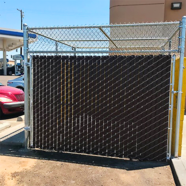 The image depicts a fence with a gate, complemented by a car parked in front, illustrating a secure enclosure