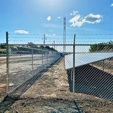 A fence adorned with solar panels, showcasing a blend of security and renewable energy technology.
