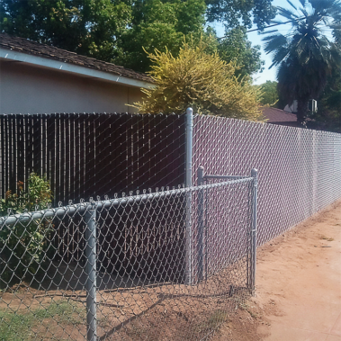 A sturdy fence encloses the front yard of a house, enhancing its curb appeal and providing privacy.