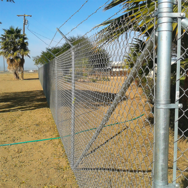 A close-up view of a chain link fence, showcasing its interwoven metal links and sturdy structure against a blurred background.