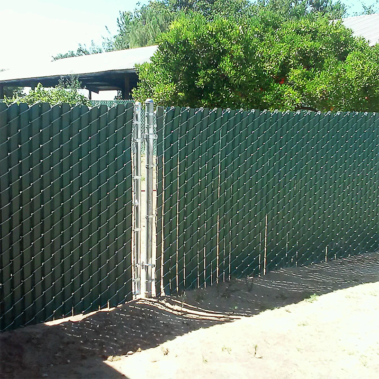 A green chain link fence with a gate, providing a secure boundary in an outdoor setting.