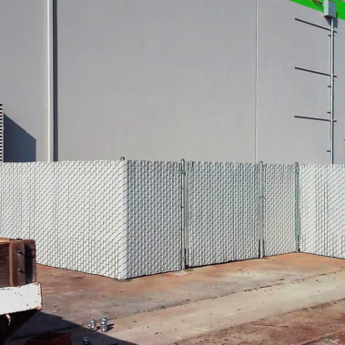 A large white fence stands prominently in front of a building, creating a distinct boundary and enhancing the view.