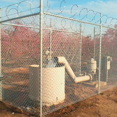 A sturdy metal gate stands alongside a water pump or well, creating a secure and rustic boundary.