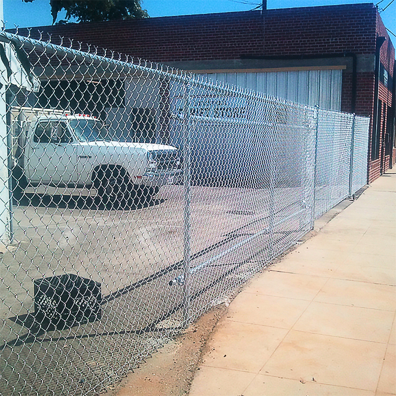 Commercial Fence featuring a truck and nearby business